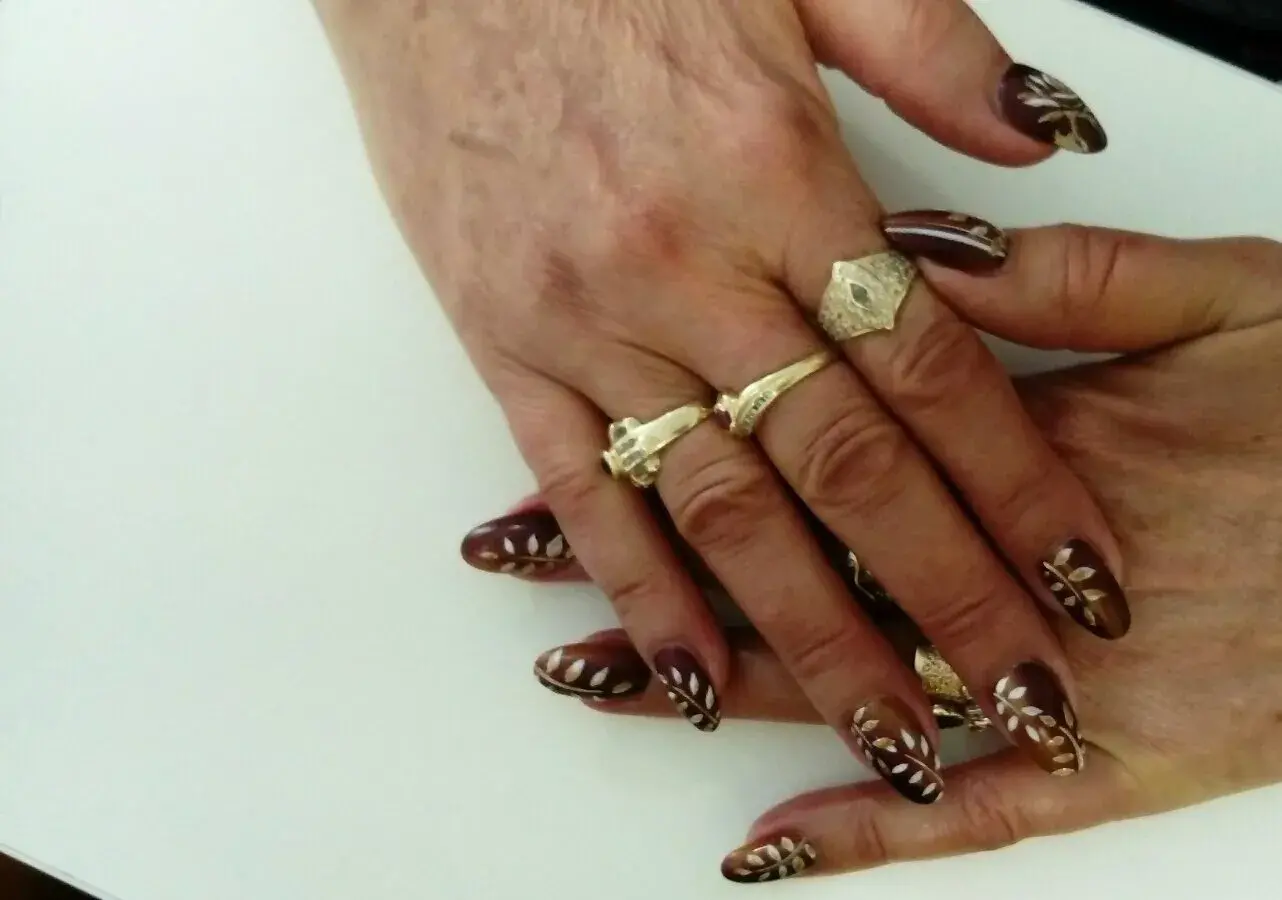 Nail art i ruke sa zlatnim prstenjem